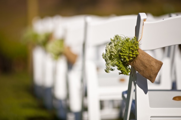 Inexpensive burlap bags and flowers to decorate the ceremony chairs. Photo by Felici Photo.